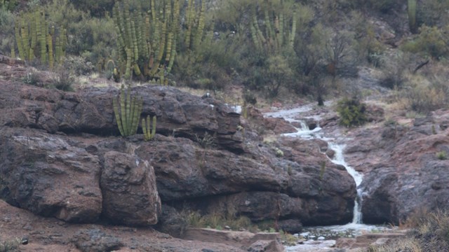 A rocky wash with two waterfalls and a running wash due to rain.